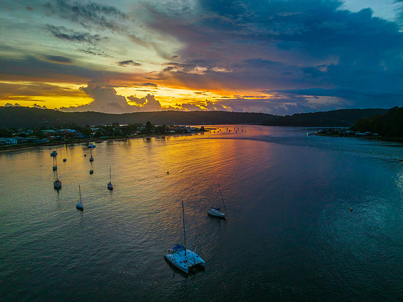 Aerial sunrise waterscape with boats, colour and clouds