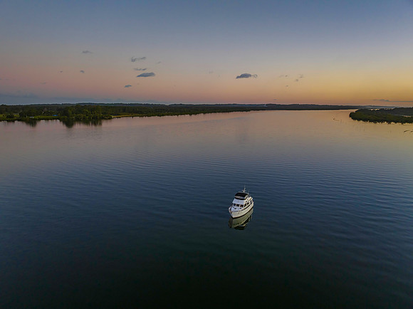 Sunset over the river with boats, reflections and the moon