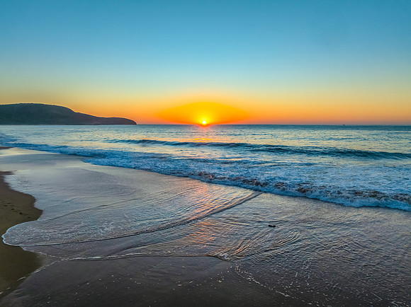Sunrise seascape with clear skies and orange horizon
