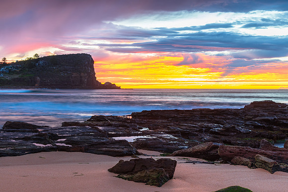 Winter sunrise by the sea shore with rain clouds