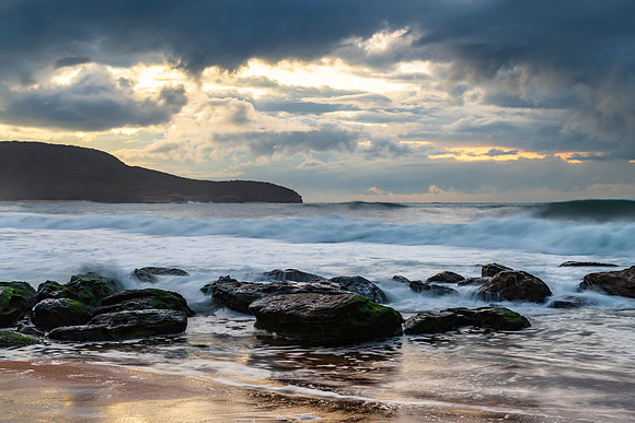 Sunrise seascape with low clouds and waves