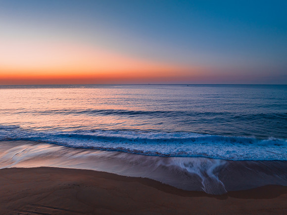 Soft sunrise seascape with hazy cloudless sky