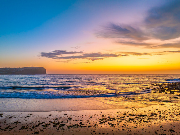 Sunrise at the seashore with colour in the clouds
