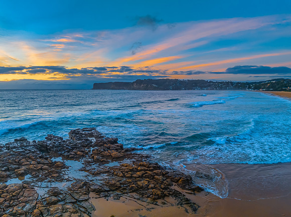 Sunrise over the sea and rock platform with high cloud