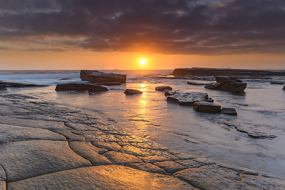 An Atmospheric Sunrise Seascape and Rock Surface