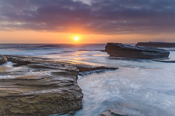 An Atmospheric Sunrise Seascape with Large Rocks