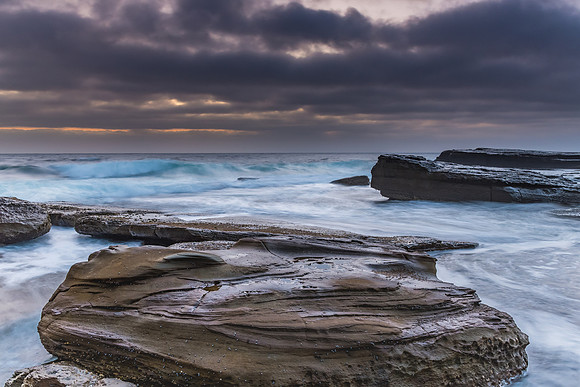 An Atmospheric Sunrise Seascape with Large Rocks