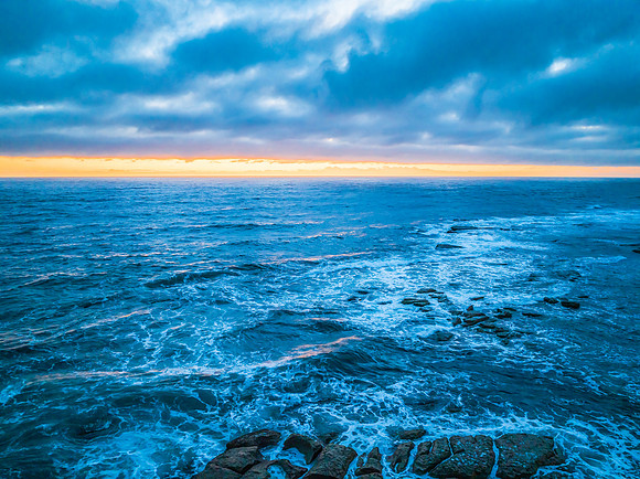 Cloudy sunrise over the ocean with rock platform
