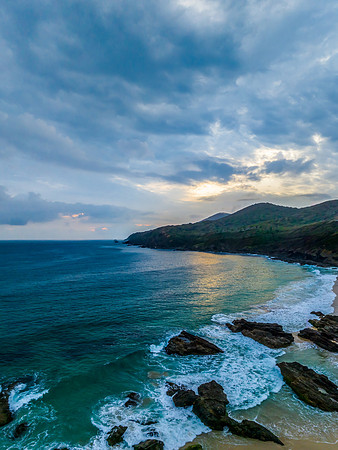 Rain clouds, rocks and sunrise at the seaside