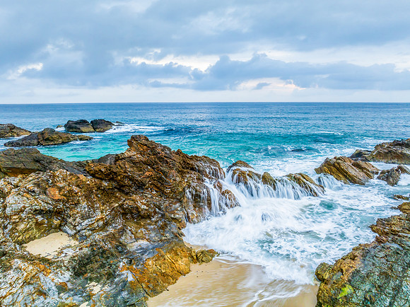 Rain clouds, rocks and sunrise at the seaside