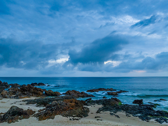 Rain clouds, rocks and sunrise at the seaside