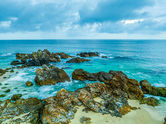 Rain clouds, rocks and sunrise at the seaside