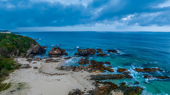 Rain clouds, rocks and sunrise at the seaside