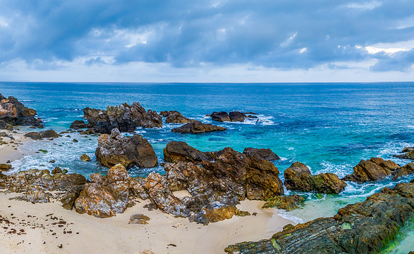 Rain clouds, rocks and sunrise at the seaside