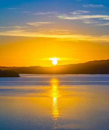 Sunrise with high cloud, boats and reflections over the water