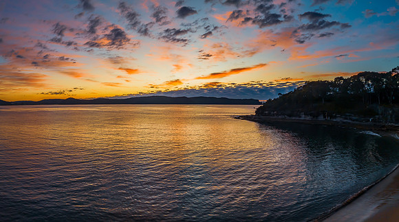 Aerial sunrise seascape with pretty cloud filled sky