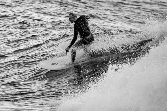 Early morning seascape with surfer catching a wave