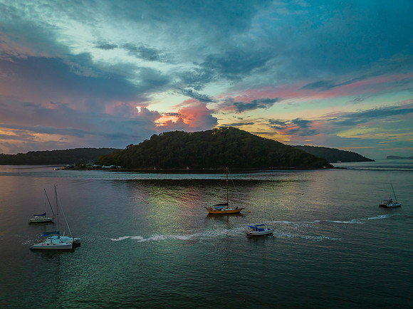 Aerial sunrise waterscape with boats, colour and clouds