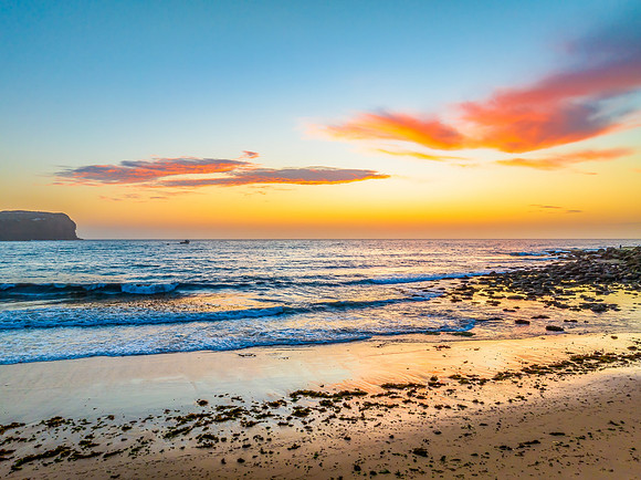 Sunrise at the seashore with colour in the clouds
