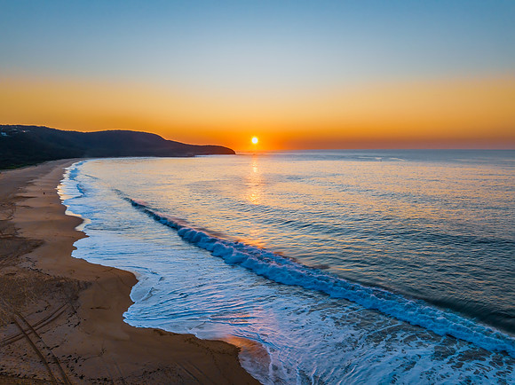 Soft sunrise seascape with full sun in a hazy cloudless sky