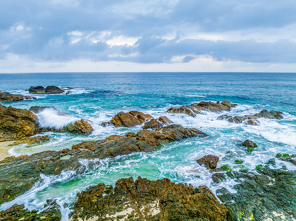 Rain clouds, rocks and sunrise at the seaside