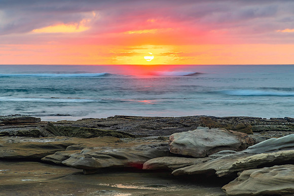 Sunrise seascape with rocky foreground
