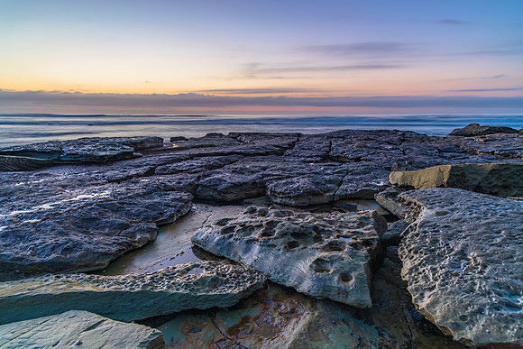 Sunrise seascape with rocky foreground