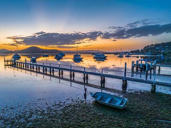 Aerial sunrise waterscape with boats, reflections and low cloud