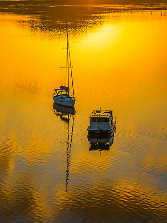Aerial sunrise waterscape with boats and golden light
