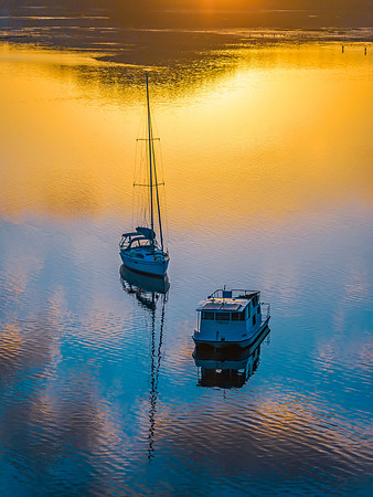 Aerial sunrise waterscape with boats and golden light