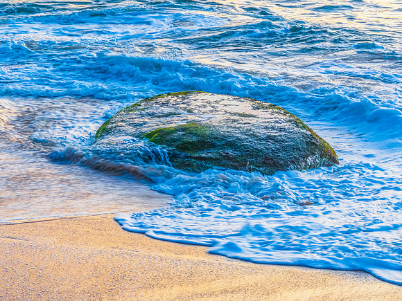 Aerial sunrise views over the ocean, beach and rock