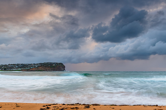 Wet weather sunrise with choppy waves at the seaside