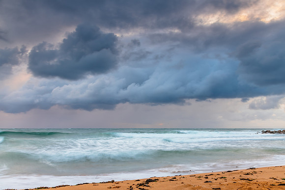 Wet weather sunrise with choppy waves at the seaside