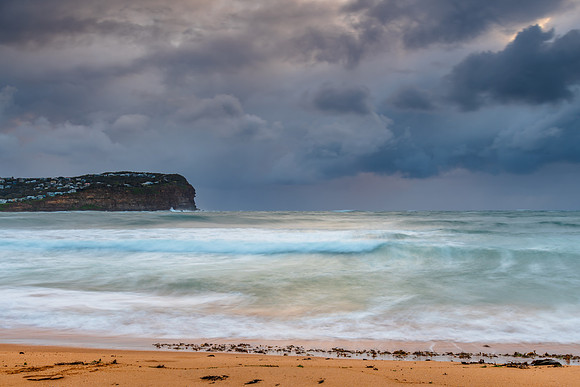 Wet weather sunrise with choppy waves at the seaside