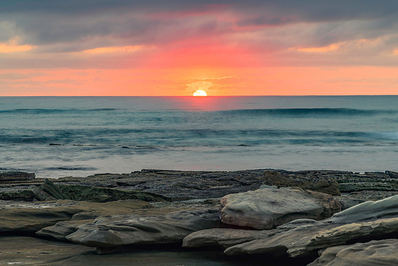 Sunrise seascape with rocky foreground