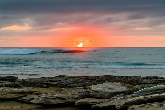 Sunrise seascape with rocky foreground