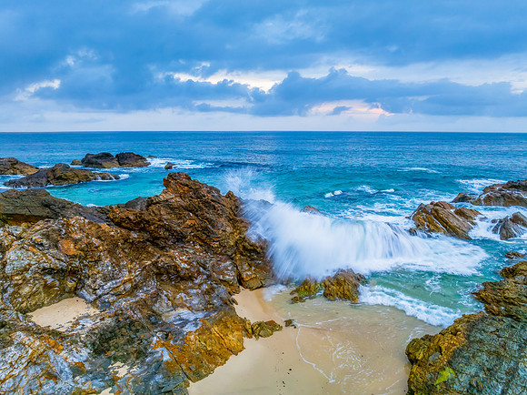 Rain clouds, rocks and sunrise at the seaside