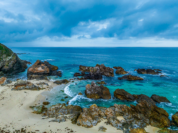 Rain clouds, rocks and sunrise at the seaside