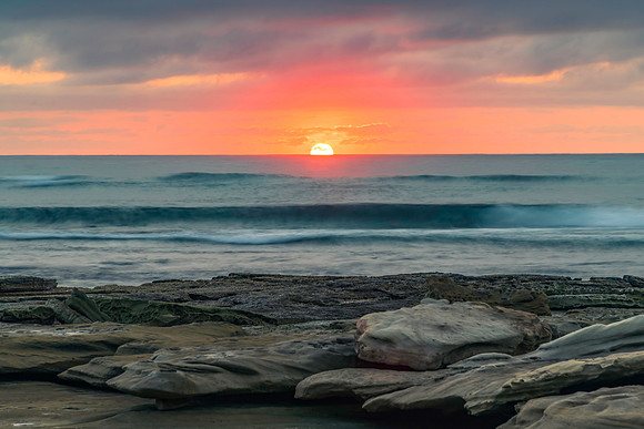 Sunrise seascape with rocky foreground