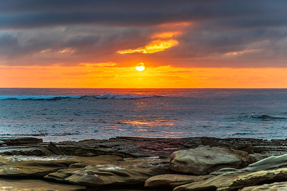 Sunrise seascape with rocky foreground