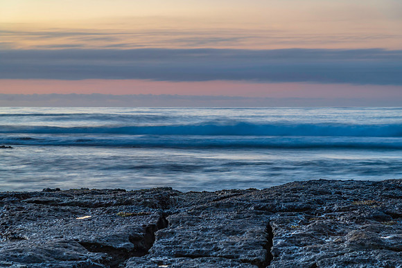 Sunrise seascape with rocky foreground