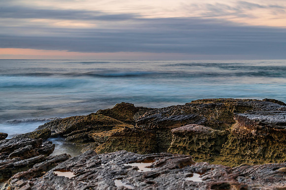 Sunrise seascape with rocky foreground