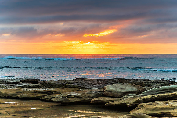 Sunrise seascape with rocky foreground
