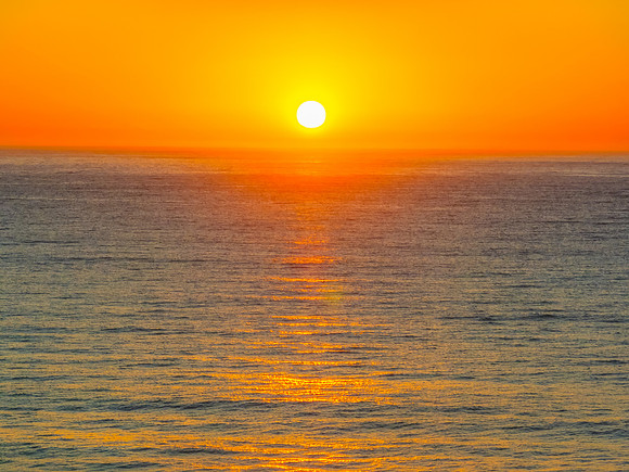 Sunrise seascape with clear skies and orange horizon