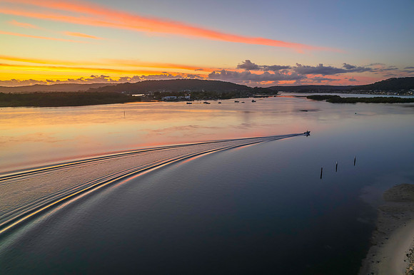 Sunrise over the bay with clouds and boat