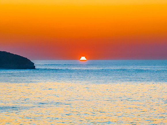 Soft sunrise seascape with hazy cloudless sky