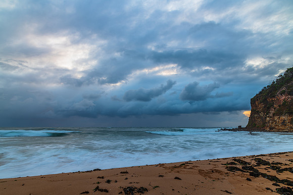 Wet weather sunrise with choppy waves at the seaside