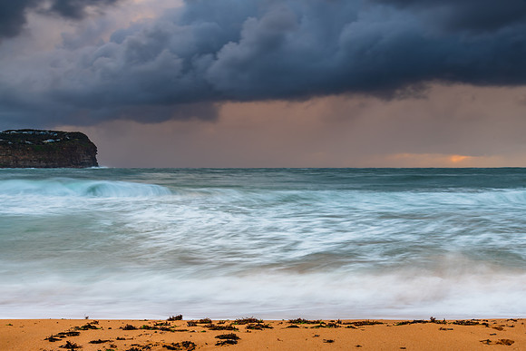 Wet weather sunrise with choppy waves at the seaside