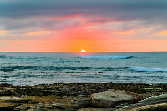 Sunrise seascape with rocky foreground
