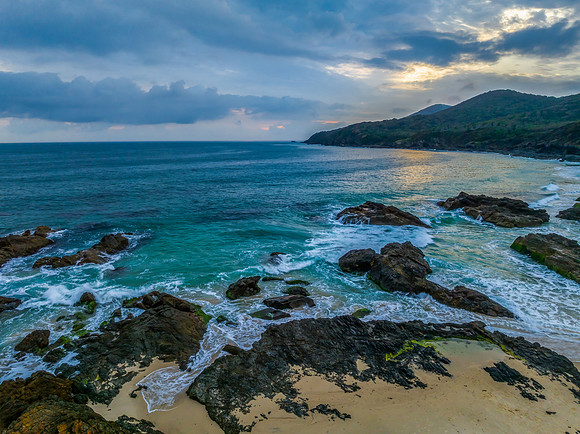 Rain clouds, rocks and sunrise at the seaside